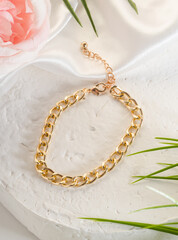 Fashion bijouterie - a large gold chain bracelet on a white stand