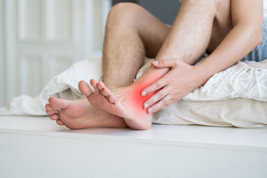 Joint inflammation, foot pain, man suffering from feet ache at home, podiatry concept
