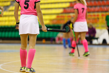 Young girl hockey player playing indoor hockey. Image of female player with stick with copy space