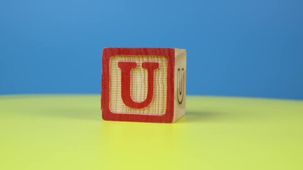 Close up shot letter "U" alphabet wooden block on surface - Powered by Adobe