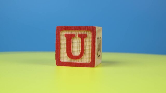 Close up shot letter "U" alphabet wooden block on surface