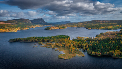 Wild landscape with lake and mountains in autumn in Lapland in Sweden from above during day with blue sky.