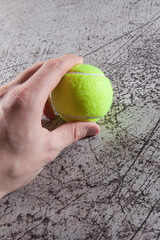 Male hand and tennis balls on asphalt tennis court