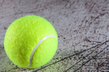 Close up of tennis ball on asphalt tennis court