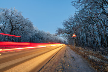 Fototapeta premium winter night forest road driving. night travel traffic light. winter wanderlust
