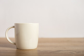 A mug with a hot drink on the table. Breakfast or coffee at night