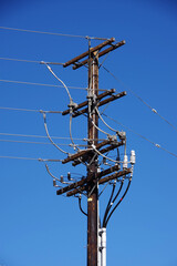 Low angle close-up view of a wooden electricity pylon for overhead power distribution