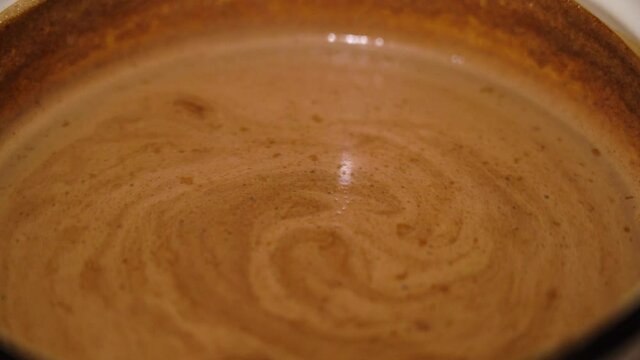 Hot cocoa is cooked in a bowl and rotated. High quality 4k footage