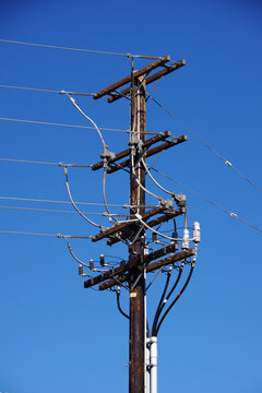 Low angle close-up view of a wooden electricity pylon for overhead power distribution