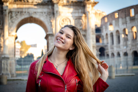 Young woman traveling to Rome. Beautiful blonde woman takes a picture of herself in front of the arch of Titus.