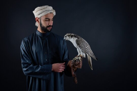 Young falconer holding a bird of prey.