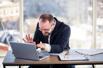 The corporate madman is sitting at the computer in the office and going crazy, the emotional...