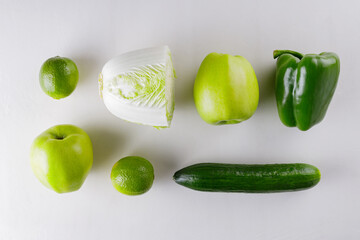 Green vegetables and fruits on white background. Healthy vegetarian food concept. Top view