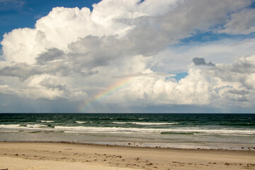 Fototapeta premium A Rainbow over the ocean, seen from the beach. 