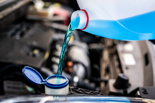 Pouring antifreeze. Filling a windshield washer tank with an antifreeze in winter cold weather...