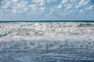 Naklejka na ściany i meble A strong November wind drives roaring waves to the shore, tearing white foam from them. All the beaches of Paphos and nearby villages are flooded with stormy waters. 