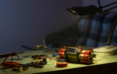 bomb making tool and dynamite bomb on the table in the light of the lamp