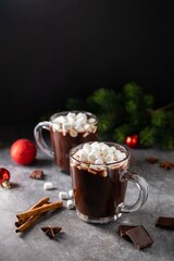 Glass mug with hot chocolate cocoa drink with marshmallow. Copy space. Dark background. Low key....
