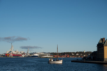 Fototapeta na wymiar A small pleasure boat in the water. Stavanger port in the background.