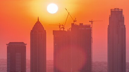 Skyline with modern architecture of Dubai business bay towers at sunset timelapse. Aerial view