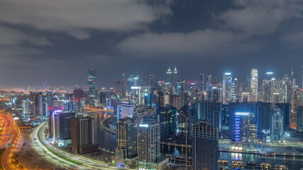 Skyline with modern architecture of Dubai business bay towers all night timelapse. Aerial view