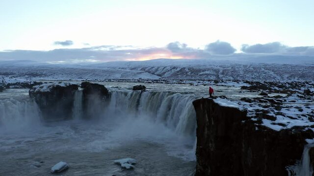 Aerial view of man walking near Godafoss waterfall, Iceland.