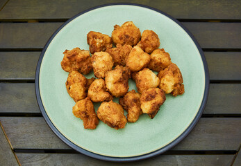 Vegan cauliflower buffalo wings on white wooden table.Tasty vegetarian food top view. crispy fried cauliflower bites