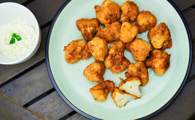 Vegan cauliflower buffalo wings on white wooden table.Tasty vegetarian food top view. crispy fried cauliflower bites