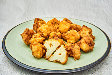 Vegan cauliflower buffalo wings on white wooden table.Tasty vegetarian food top view. crispy fried...