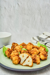 Vegan cauliflower buffalo wings on white wooden table.Tasty vegetarian food top view. crispy fried cauliflower bites
