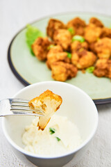 Vegan cauliflower buffalo wings on a fork. Tasty vegetarian food close up. crispy fried cauliflower bites