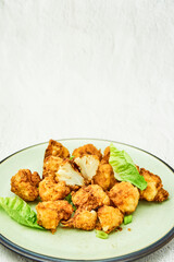 Vegan cauliflower buffalo wings on white wooden table.Tasty vegetarian food top view. crispy fried cauliflower bites