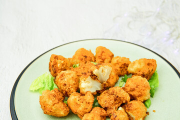 Vegan cauliflower buffalo wings on white wooden table.Tasty vegetarian food top view. crispy fried cauliflower bites