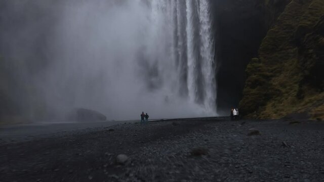 Hyperlapse people standing in front of Skogafoss waterfall in Iceland.