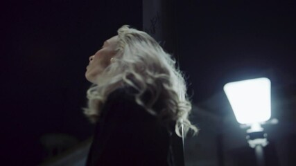 Young woman night city looking up sky on walk in downtown street lights. 