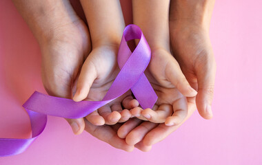 Violet purple ribbon symbolic bow colour on helping hand support 