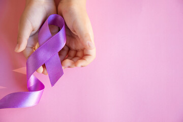 Child hands holding purple ribbons, Alzheimer's disease, Pancreatic cancer, Epilepsy awareness, world cancer day