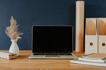 Open laptop and stationery on wooden table