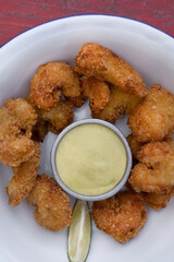 Top view of fried breaded shrimps with avocado mayonnaise and lemon. 