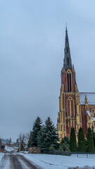 Obraz premium Neo-Gothic cathedral church in the town of Gervyaty in Belarus in the winter on dramatic sky background. Space for text.