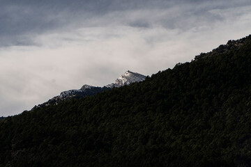 Snowy mountain with clouds at sunset