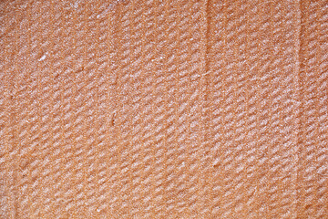 Fototapeta premium The texture of the wet yellow cardboard is covered with frost.