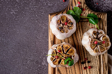 Roasted garlic on a wooden cutboard, copy space. 