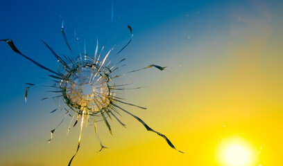 Hole in the glass from a bullet on the background of the flag of Ukraine