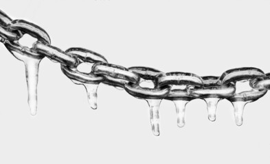 Icicles on a chain, frosted metal on a light background.