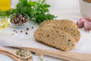 seitan or vegan meat sliced with spices such as oregano, pepper, garlic, and parsley.
