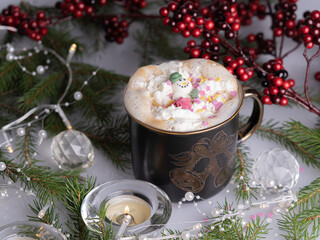 A mug of coffee, sprigs of spruce, New Year's garland, a candle on the table. Christmas decorations, Christmas still life. Concept, holiday, congratulation.