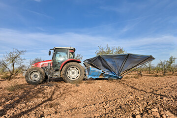 Tractor picking almonds with the umbrella.