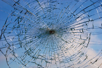 Broken glass from the front of a car and the sky in the background