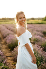 Fototapeta na wymiar the bride in a white dress on the lavender field